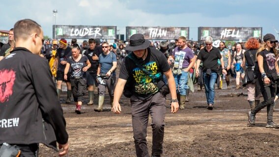 Ein Wacken Besucher läuft durch den Matsch © NDR Foto: Lena Storm