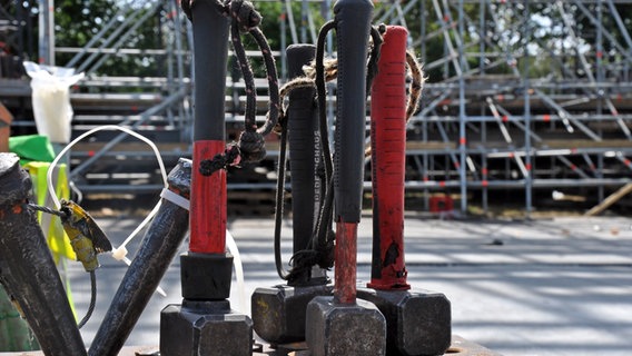 Kleinere und größere Hammer mit schwarz-roten Griffen stehen beim Aufbau der Bühnen auf dem Festival-Gelände in Wacken. © NDR Foto: Eva Schulze-Gabrechten