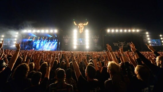 Menschen strecken ihre Hand als "Pommesgabel" zu der Bühne. © ICS Festival Service GmbH 