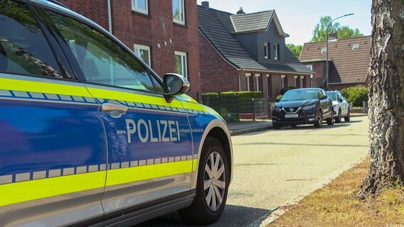 Ein Streifenwagen steht vor einem Wohnhaus bei einer Hausdurchsuchung in Itzehoe. © NDR 