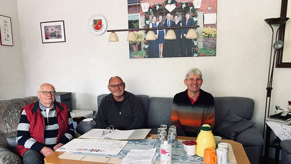 Lorenz Lorenzen (eh.BM; links), Harald Schmalfeld (Nachbar; Mitte), Klaus Groenewold (rechts) sitzen auf einer Couch im Wahlwohnzimmer © NDR Foto: Torsten Creutzburg