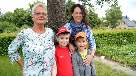 Christiane Jordan, Emilio, Tamino und Mutter Liane Preuß posieren im Garten. © NDR Foto: Astrid Wulf