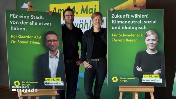 Samet Yilmaz und Theresa Boysen (beide Grüne) posieren neben ihren Wahlplakaten. © NDR 