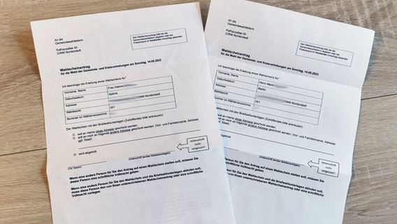 Zwei Wahlscheinanträge für die Wahl der Gemeinde- und Kreisvertretungen in Norderstedt liegen auf einem Tisch. © NDR 