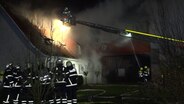 Mehrere Feuerwehrleute löschen ein brennendes Gebäude in der Gemeinde Wangels. © NonStopNews 