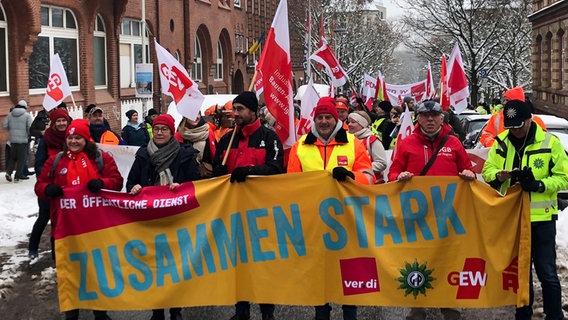 Im Zuge eines Warnstreiks tragen Menschen ein Banner vor sich mit der Aufschrift: "Zusammen stark". © NDR Foto: Julia Jänisch