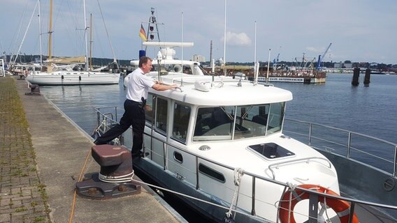 Wasserschutzpolizist Ingo Berger betritt sein Einsatzboot, die "NEU MÜHLEN", in der Kieler Förde. © Cassandra Arden Foto: Cassandra Arden