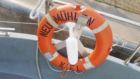 Die Nahaufnahme eines Rettungsring mit dem Schriftzug "NEU MÜHLEN KIEL", der an einem Boot installiert ist. © Cassandra Arden Foto: Cassandra Arden