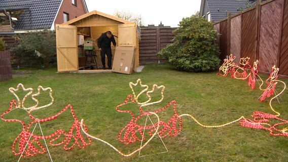 In einem Garten ist eine Weihnachtsbeleuchtung aufgebaut. © NDR 