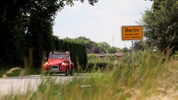 Ein Oldtimer fährt auf der Straße, die in den Ort "Berlin" im Kreis Segeberg führt. © NDR Foto: Tobias Senff