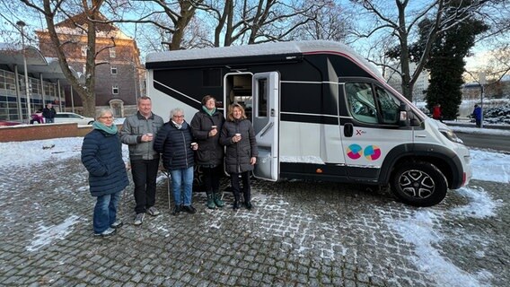 Mehrere Menschen stehen vor einem Wohnmobil © NDR Foto: Friederike Hoppe