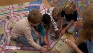 Kinder spielen auf einem Spieleteppich. © NDR Foto: NDR Screenshots