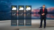 NDR Moderator Sebastian Wache steht im Studio mit der Wettervorhersage. © NDR 