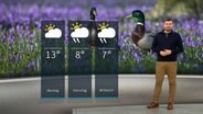 NDR Moderator Sebastian Wache steht im Studio mit der Wettervorhersage. © NDR 