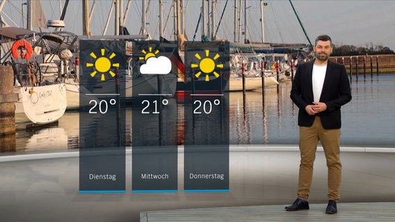 Wetterexperte Sebastian Wache steht im Studio mit der Wettervorhersage. © NDR 
