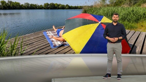 Wetterexperte Sebastian Wache steht im Studio mit der Wettervorhersage. © NDR 