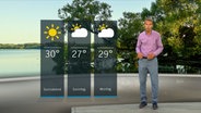 Wetterexperte Meeno Schrader steht im Studio mit der Wettervorhersage. © NDR 