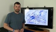 Wetterexperte Sebastian Wache steht vor einem Monitor © NDR 