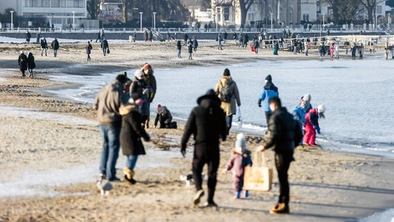 Spaziergänger genießen bei 1 Grad Lufttemperatur, Windstille und Sonnenschein ihren Sonnabendspaziergang am Strand von Travemünde. © dpa - Bildfunk Foto: Markus Scholz