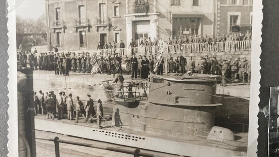 Ein altes Foto zeigt zahlreiche Menschen um ein U-Boot. © NDR 