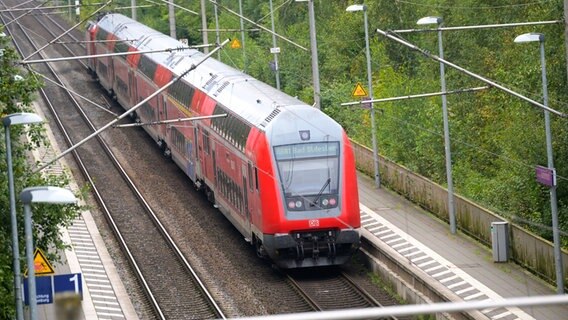 Ein doppelstöckiger Regionalzug der Deutschen Bahn (DB) fährt durch einen Bahnhof.  Foto: Jonas Walzberg