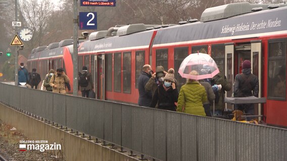 Passagiere steigen in einen Zug ein. © NDR 
