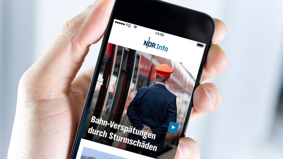 Eine Hand hält vor einem hellen Hintergrund ein Spmartphone auf dem die Startseite der NDR Info App zu sehen ist. © fotolia, NDR Foto: bloomua