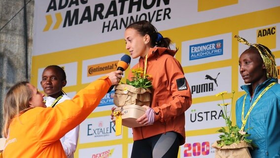 Auf der Bühne interviewt Susanne Neuß den Marathon-Siegerin der Frauen Matea Parlov Kostro. © NDR Foto: Luisa Müller