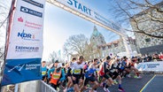 Marathoni laufen durch den Torbogen beim Hannover-Marathon 2022. © eichels: Event GmbH 
