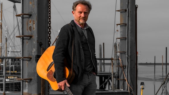 Musiker Otto Groote mit einer Gitarre am Hafen © https://www.otto-groote.net/ 