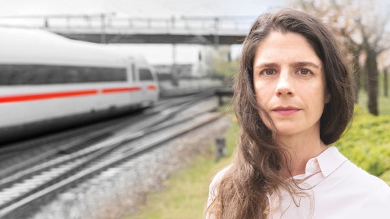 Eine Frau steht vor Bahngleisen in Eschede. © NDR Foto: Paula Winkler