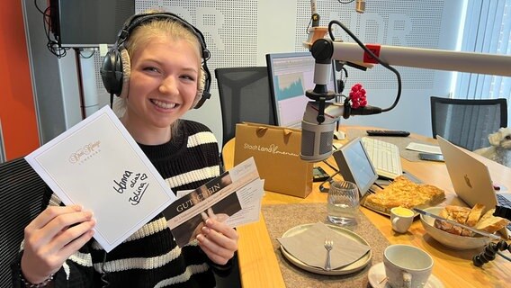 Hanna-Marie Hofmann zeigt ihr mitgebrachtes Requisit im Aufnahmestudio. © ARD Foto: Marlene Kukral