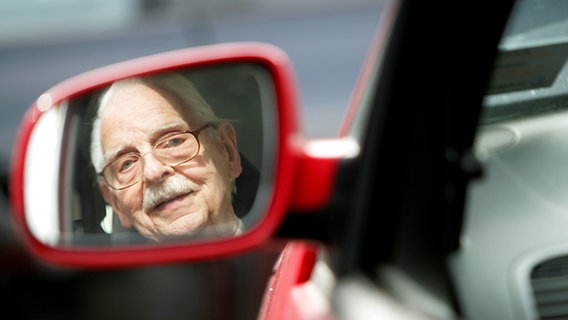 Ein älterer Mann fährt Auto und schaut dabei in den Rückspiegel © picture-alliance/dpa Foto: Rolf Vennenbernd