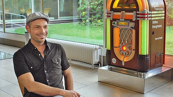 Der Sänger Roger Cicero sitzt lachend im kleinen Foyer des Landesfunkhauses in Hannover. © NDR Foto: NDR
