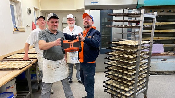 Schorse übergibt ein Dabbi DAB+ Radio an Axel Körner von der Bäckerei und Konditorei Brüggemann in Schüttorf. © NDR Foto: Bernd Drechsler