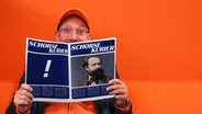 Schorse mit einer Klatsch-Zeitschrift, die "Schorse Kurier" heißt © NDR / picture-alliance / akg-images Foto: Luisa Müller / akg-images