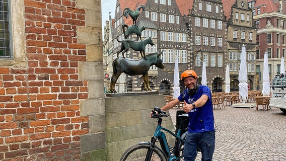 NDR Reporter "Schorse" mit dem Fahrrad vor den Bremer Stadtmusikanten © NDR Foto: Bernd Drechsler