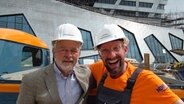 Henning Zühlsdorff, Pressesprecher der Leuphana Universität in Lüneburg mit Schüssel Schorse vor dem Neubau des Hauptgebäudes. © NDR 