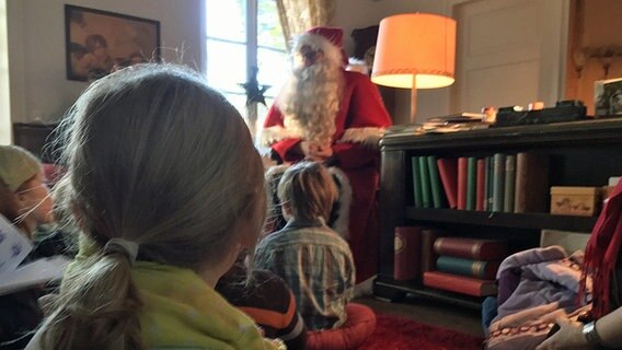 Kinder sitzen vor dem Weihnachtsmann auf dem Fußboden © NDR Foto: Hendrik Millauer