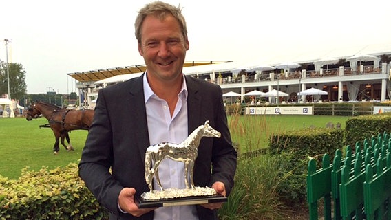 Sport-Redakteur Jörg Schimmelpfennig hält einen Preis in der Hand © NDR Foto: Hans-Wilhelm Watermann