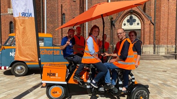 Petra Bohlen, Schorse, Timo Plenter, Ina Stuke, Roman Rohjans, Anke Raczkowicz und Stephan Bohlen (v.l.) auf dem Team-Rad in Friesoythe. © NDR Foto: Bernd Drechsler