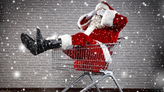Ein Weihnachtsmann sitzt in einem Einkaufswagen. © fotolia Foto: magdal3na