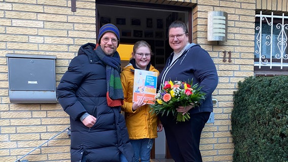 Andi Gervelmeyer übergibt an Ina Glaser aus Oldenburg und ihre Tochter den Gutschein für die 5.000 Euro Traumreise. © NDR Foto: Bernd Drechsler