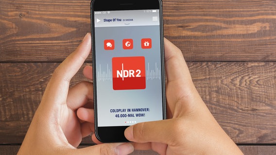 Zwei Hände halten ein Smartphone, auf dem die Startseite der NDR 2 App zu sehen ist. © NDR 