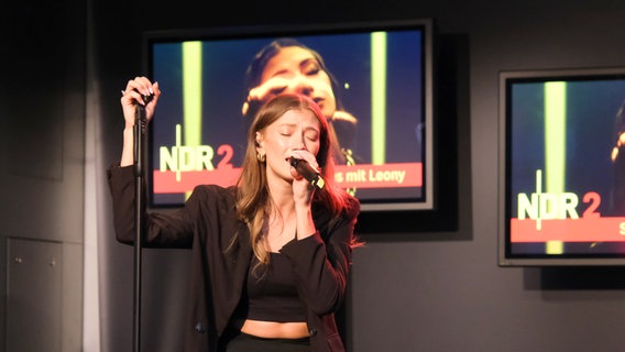 Leony bei NDR 2 am 5. Juli 2023: Sie singt mit geschlossenen Augen und stützt sich auf den Mikrofonständer © NDR 2 Foto: Viktoria Wanka
