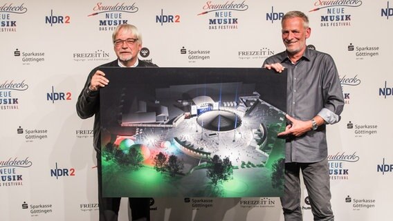 Göttingens Oberbürgermeister Rolf-Georg Köhler und NDR 2 Programmchef Torsten Engel (rechts) mit einer Illustration der neuen NDR 2 City Stage auf dem Schützenplatz 2019. Göttingens Oberbürgermeister Rolf-Georg Köhler und NDR 2 Programmchef Torsten Engel (rechts) mit einer Illustration der neuen NDR 2 City Stage auf dem Schützenplatz 2019. © NDR Foto: Axel Herzig