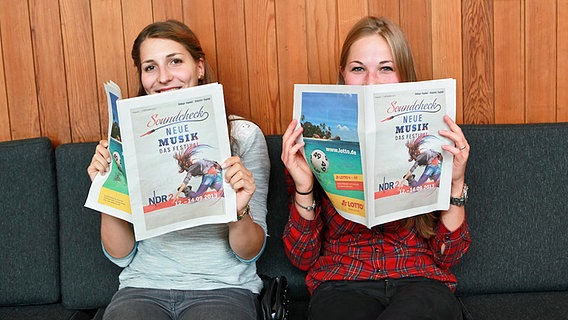 Festival-Besucher lesen die Zeitung. © NDR 2 Foto: Axel Herzig