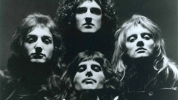 Queen 1975 (v. li.): John Deacon, Brian May und Roger Taylor, vorn: Freddie Mercury © EMI Music Germany 