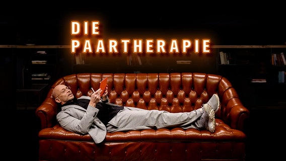 Ein Mann liegt auf einem braunen Ledersofa und blickt auf ein Tablet. Darüber der Schriftzug "Die Paartherapie". © NDR Foto: Janine Meyer