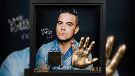 Handabdruck in edel gestaltetem Rahmen von Robbie Williams für "Hand in Hand für Norddeutschland" © NDR 2 Foto: Niklas Kusche
